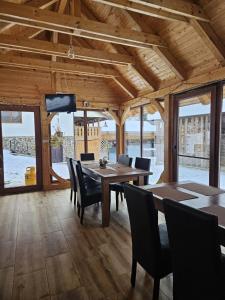 ein Esszimmer mit Tisch und Stühlen und einem Fernseher in der Unterkunft Pensiunea Mateș in Arada + 6 Fotos