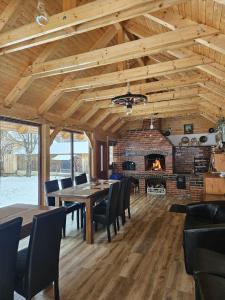 ein Esszimmer mit Tisch und Kamin in der Unterkunft Pensiunea Mateș in Arada