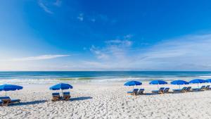 a group of chairs and umbrellas on a beach at Phoenix East 002 in Orange Beach