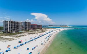 a beach with people and umbrellas and the ocean at Phoenix East 002 in Orange Beach