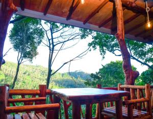 a table and chairs on the porch of a cabin at Eco Cabins Hideaway Ella in Ella