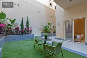 a patio with a table and chairs and plants at Prime Residence Zayed Heights in Sheikh Zayed