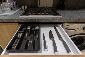 a stove top oven with utensils on top of it at Prime Residence Zayed Heights in Sheikh Zayed