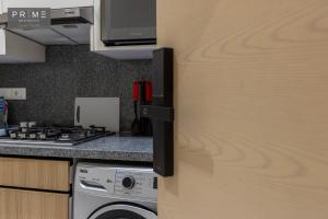 a kitchen with a washer and a stove and a refrigerator at Prime Residence Zayed Heights in Sheikh Zayed +151 photos