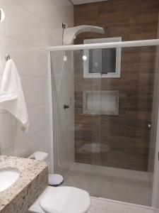 a bathroom with a shower with a toilet and a sink at Calmaria in Matinhos +17 photos
