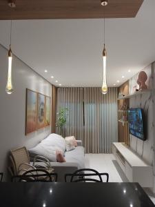 ein Wohnzimmer mit einem Bett und einigen Stühlen in der Unterkunft Calmaria in Matinhos