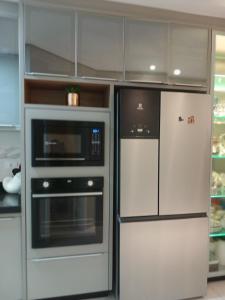 eine Küche mit Kühlschrank und Mikrowelle in der Unterkunft Calmaria in Matinhos