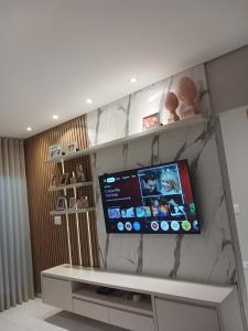 a flat screen tv on a marble wall at Calmaria in Matinhos