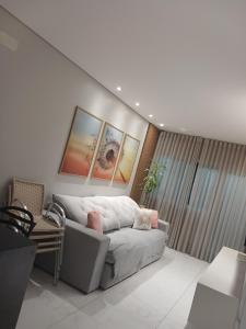 ein Wohnzimmer mit einer weißen Couch in einem Zimmer in der Unterkunft Calmaria in Matinhos