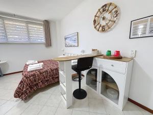 a room with a desk and a bed with a clock on the wall at I 3 Moschettieri vicino a Terme e Unitus, Parcheggio libero in Viterbo