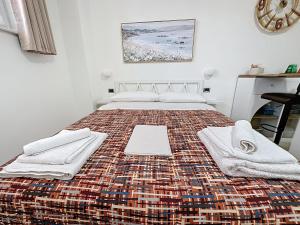 een slaapkamer met een groot bed met handdoeken erop bij Alloggio Turistico - I tre Moschettieri - Zona Universitaria e Tribunale Nuovo in Viterbo