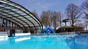 a large swimming pool with a blue slide at Boshuis Rosanne in Meijel