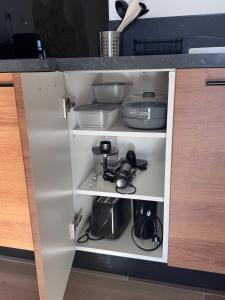 a cupboard filled with dishes and other kitchen items at Studio Rénové de Charme en Provence in Caumont-sur-Durance +9 photos