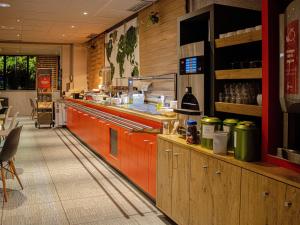 a fast food restaurant with a counter and a counter at ibis Rennes Cesson in Cesson-Sévigné