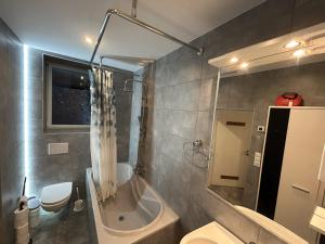 ein Badezimmer mit Badewanne, Toilette und Waschbecken in der Unterkunft Helmstedt Zentrum - Gemeinschaftshaus & Garten in Helmstedt