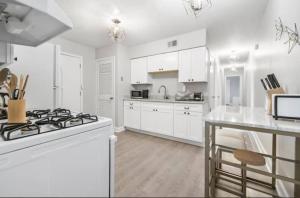 eine weiße Küche mit einem Herd und einer Theke in der Unterkunft Parkside & Broadview Memphis Comfort in City Ctr in Memphis + 35 Fotos