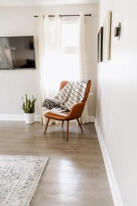 ein Wohnzimmer mit einem Stuhl und einem Fenster in der Unterkunft Parkside & Broadview Memphis Comfort in City Ctr in Memphis