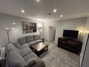 ein Wohnzimmer mit Sofa und Flachbildfernseher in der Unterkunft Helmstedt Zentrum - Gemeinschaftshaus & Garten in Helmstedt