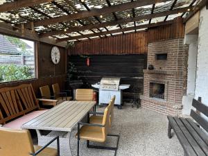 eine Terrasse mit einem Tisch und einem gemauerten Kamin in der Unterkunft Helmstedt Zentrum - Gemeinschaftshaus & Garten in Helmstedt