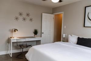 ein Schlafzimmer mit einem weißen Bett und einem Schreibtisch in der Unterkunft Parkside & Broadview Memphis Comfort in City Ctr in Memphis