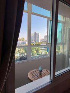 a window with a table and a view of a city at Relaxing Apartment Near the Beach Malabata Tanger in Tangier
