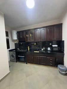 a large kitchen with wooden cabinets and a stove at Relaxing Apartment Near the Beach Malabata Tanger in Tangier