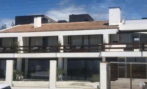 a large white building with windows and a roof at Pé na areia 5 in Torres