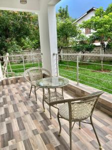 a patio with a glass table and two chairs at Tiny Card Milimani Homes in Kisumu +1 photo