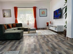 a living room with a couch and a table at Tiny Card Milimani Homes in Kisumu