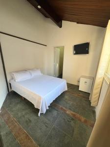 a bedroom with a white bed in a room at Pé na areia 5 in Torres