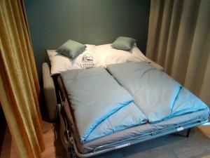 a bed with two pillows on top of it at Lakeside Central Apartment Wörthersee - Free covered Parking, Train & Bus & Supermarket with Supercharger in Sekull