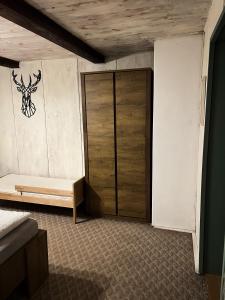 a bedroom with a bed and a wooden door at Chata Rychnovanka in Zdobnice