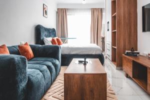 a living room with a blue couch and a bed at Kilimani Chic Studio in Nairobi