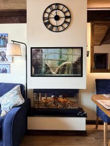 un salon avec une cheminée avec une horloge au mur dans l'établissement 617 Manoir Savoie, à Arc 1950