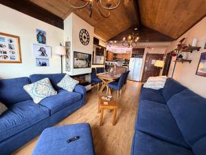 un salon avec un canapé bleu et une table dans l'établissement 617 Manoir Savoie, à Arc 1950