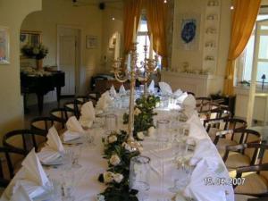 einen langen Tisch mit weißer Bettwäsche und Blumen darauf in der Unterkunft Hotel Gasthaus Krone in Köln