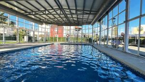 a swimming pool in a building with glass windows at Torremar Natura Julia in Vera +27 photos