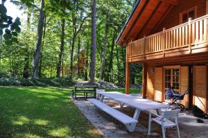 een picknicktafel en bank buiten een hut bij La Grande Ourse in Durbuy