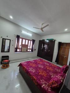 a bedroom with a large bed with a purple blanket at Kripanidhi Homestay in Jodhpur