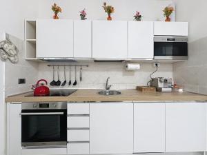 a white kitchen with white cabinets and a sink at I 3 Moschettieri vicino a Terme e Unitus, Parcheggio libero in Viterbo