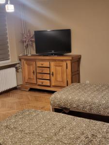 - une télévision sur une commode en bois dans l'établissement Apartament Bajka, à Bolesławiec