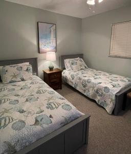 une chambre avec deux lits et une table avec une lampe dans l'établissement Refreshing oceanfront gem Remarkable sunrises, à New Smyrna Beach 24 autres photos