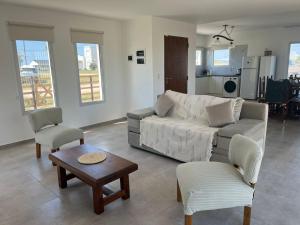 a living room with a couch and chairs and a table at Ecos de mar in Mar del Sur