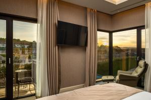 een slaapkamer met een bed en een groot raam met een televisie bij ISSA Resort in Turda