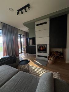 a living room with a couch and a fireplace at Chill domek in Grzybowo