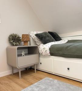 a white bedroom with a bed and a tv at Chill domek in Grzybowo