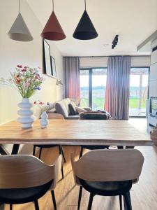 a living room with a wooden table and chairs at Chill domek in Grzybowo