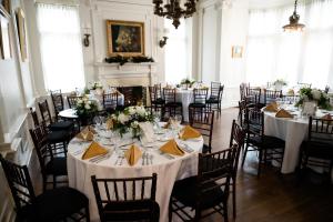 a room full of tables and chairs with white tablecloths at Mansions on Fifth in Pittsburgh
