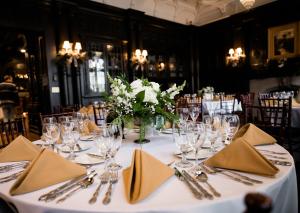 een tafel voor een bruiloft met een vaas met bloemen bij Mansions on Fifth in Pittsburgh