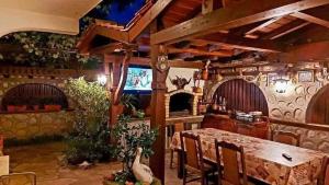 ein Esszimmer mit Tisch und Fernseher in der Unterkunft Boyadjiyski Guest House in Bansko